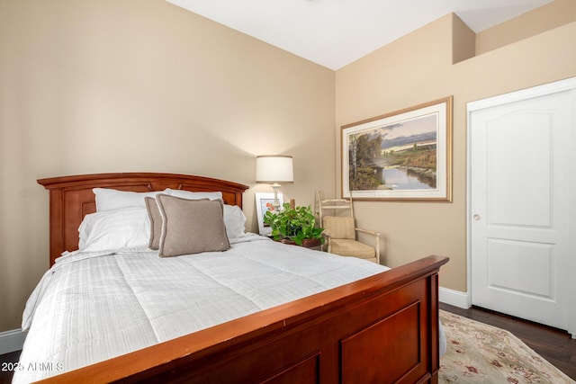 bedroom featuring baseboards and dark wood-type flooring
