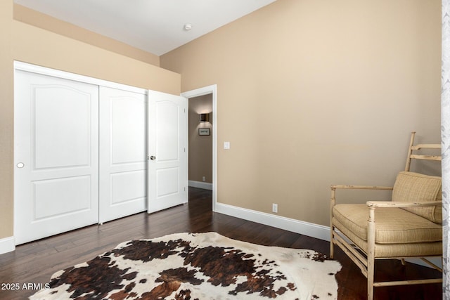bedroom with baseboards, dark wood-style floors, and a closet