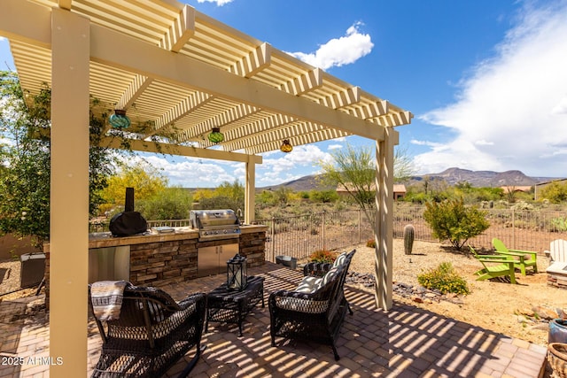 view of patio featuring area for grilling, fence, a mountain view, and a grill