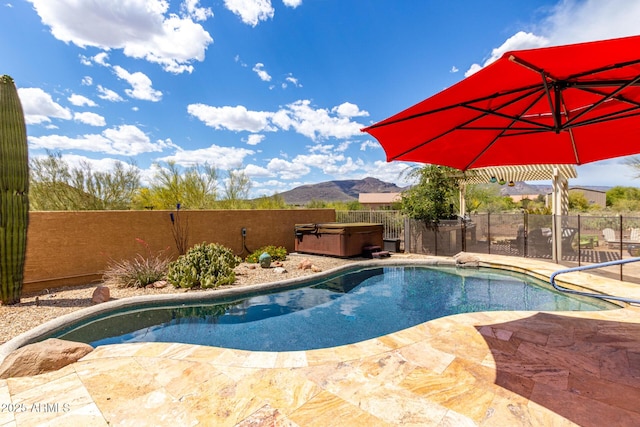view of pool featuring a fenced backyard, a mountain view, a hot tub, and a patio area