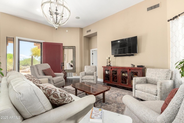 living area featuring wood finished floors, a chandelier, and visible vents