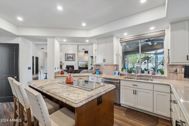 kitchen with dark wood-type flooring, a center island, decorative backsplash, and stainless steel dishwasher