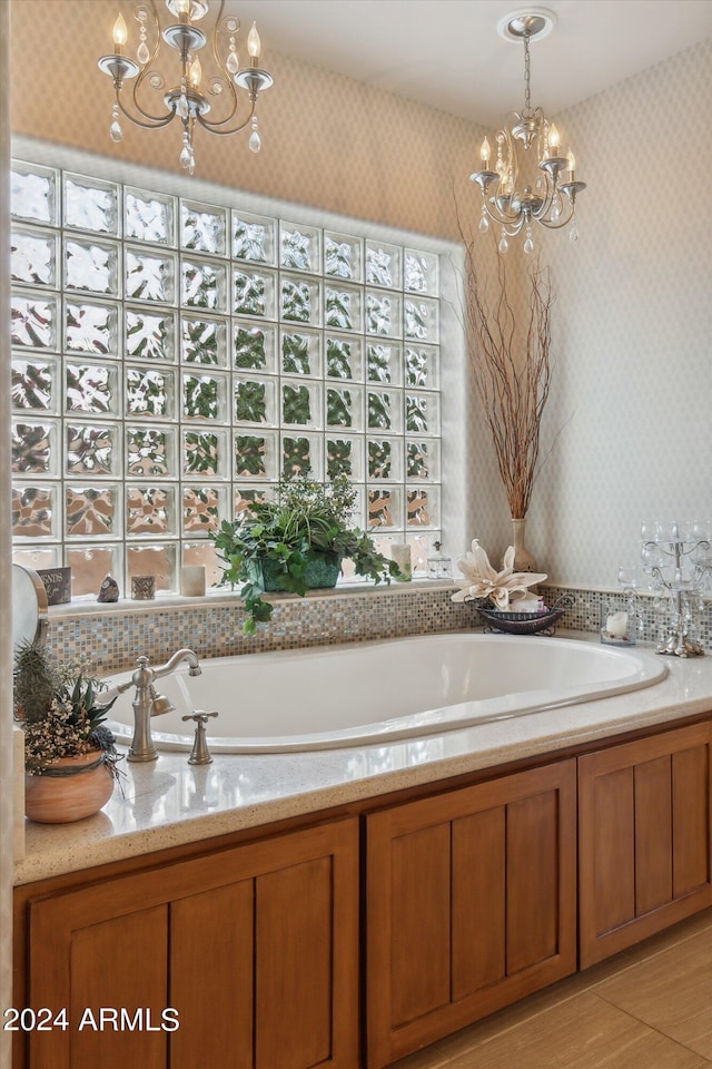 bathroom featuring a tub to relax in and a notable chandelier