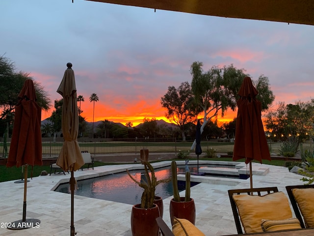 pool at dusk featuring a patio area