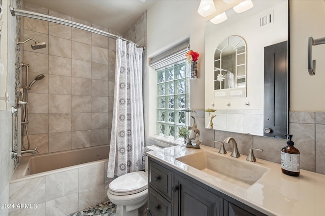 full bathroom with plenty of natural light, toilet, vanity, and tile walls