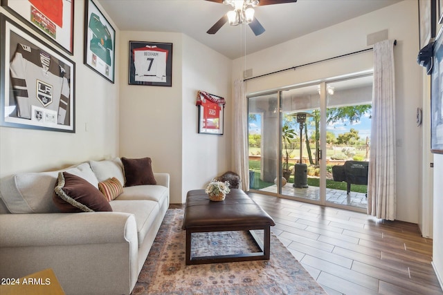 living room with dark hardwood / wood-style flooring and ceiling fan