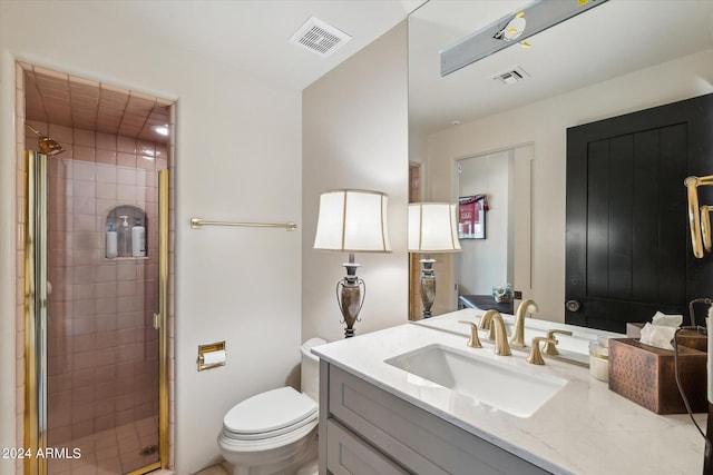 bathroom with toilet, a shower with door, and vanity