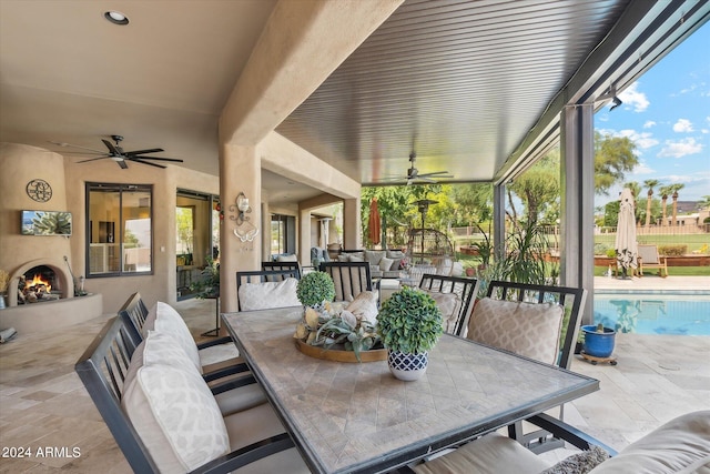 view of patio / terrace featuring an outdoor living space with a fireplace and ceiling fan