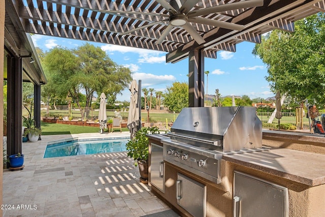 view of pool with a grill, a patio area, a pergola, exterior kitchen, and ceiling fan