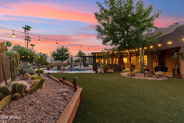 yard at dusk with a fenced in pool and a patio