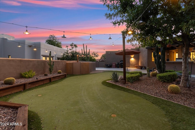 yard at dusk featuring a patio