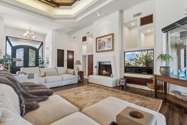 living room with french doors, a high ceiling, an inviting chandelier, and dark hardwood / wood-style flooring