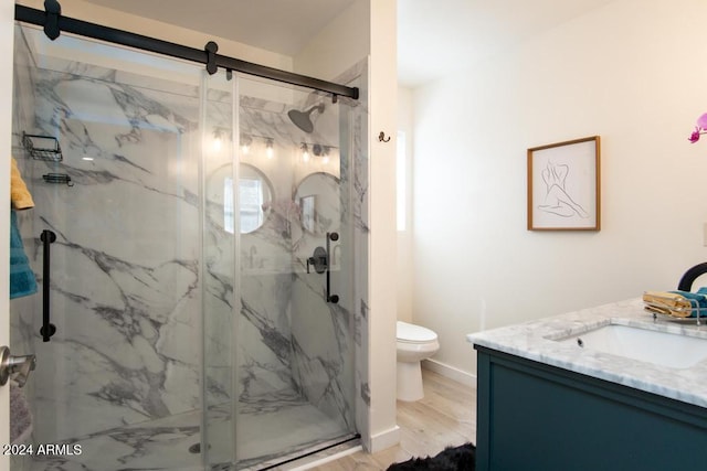 bathroom with vanity, wood-type flooring, an enclosed shower, and toilet