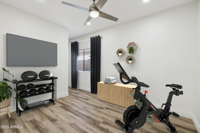 workout room with baseboards, light wood-style flooring, and a ceiling fan