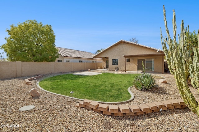 back of house featuring stucco siding, a fenced backyard, a lawn, and a patio