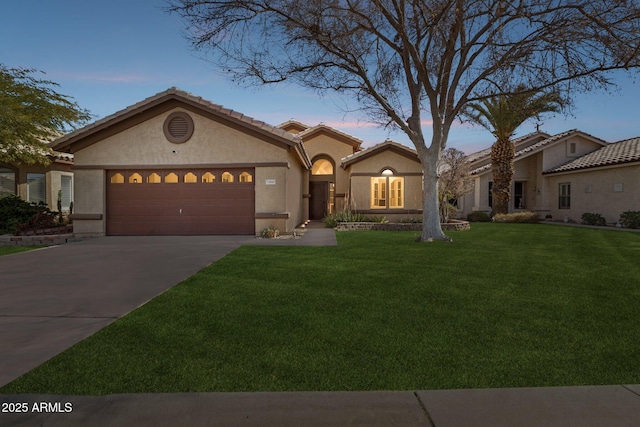 mediterranean / spanish home with a garage, a tile roof, driveway, a lawn, and stucco siding