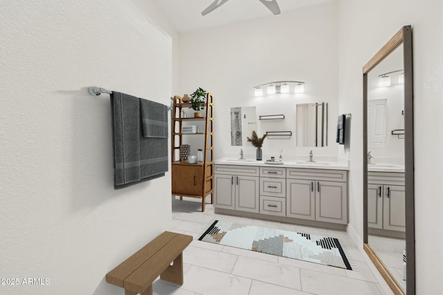 bathroom featuring double vanity, marble finish floor, ceiling fan, and a sink