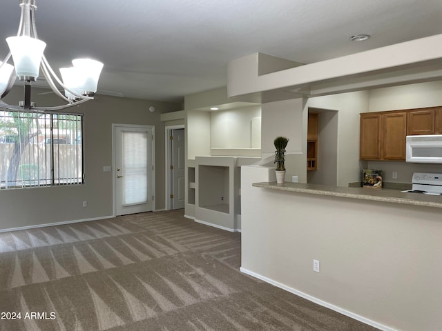 kitchen featuring an inviting chandelier, decorative light fixtures, carpet floors, and white appliances