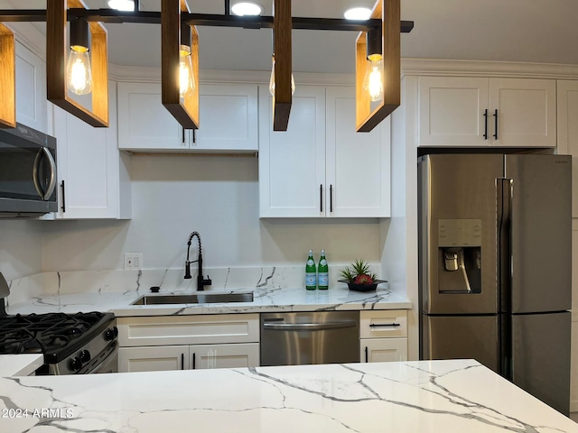 kitchen with white cabinets, stainless steel appliances, hanging light fixtures, and sink