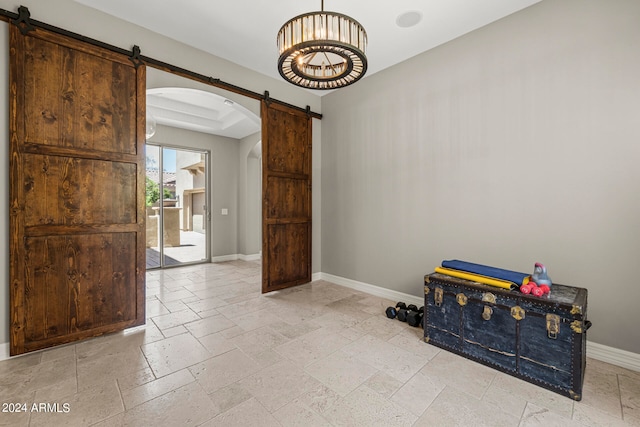 interior space featuring a barn door and a raised ceiling