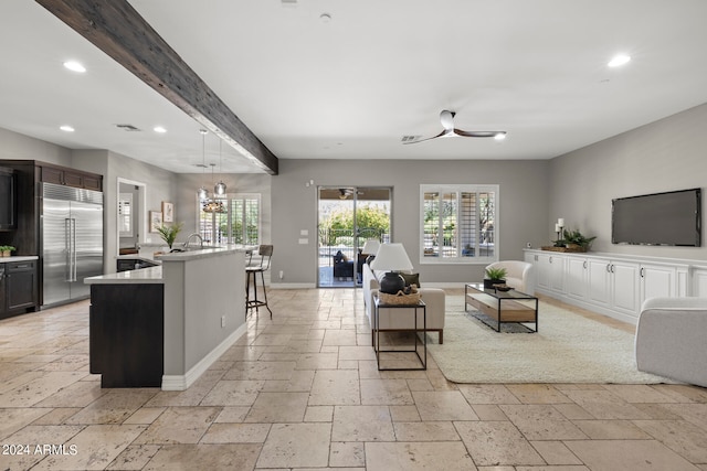 living room with sink, beamed ceiling, and a chandelier