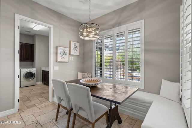 dining room with a chandelier and washer / dryer