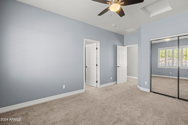 unfurnished bedroom featuring a closet, light colored carpet, and ceiling fan