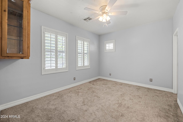 carpeted spare room with ceiling fan