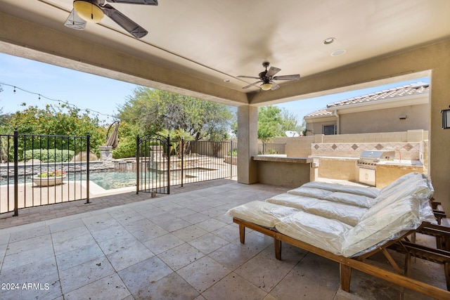 view of patio / terrace with ceiling fan, area for grilling, a fenced in pool, and an outdoor kitchen