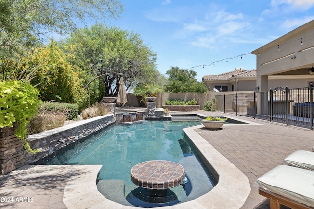 view of pool featuring an in ground hot tub, pool water feature, and a patio