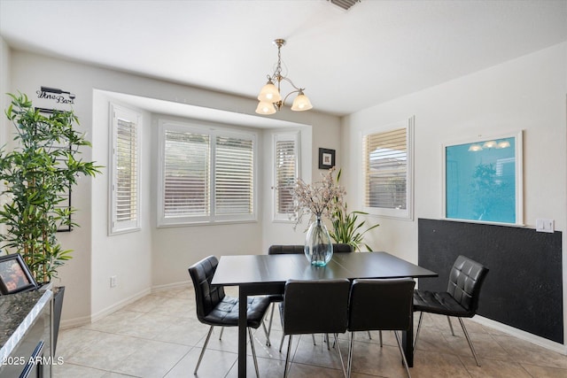 tiled dining room with a notable chandelier