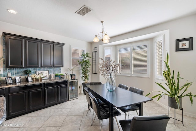 dining room with wine cooler, light tile patterned floors, and a chandelier