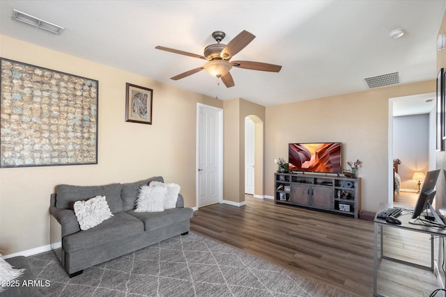 living room with dark wood-type flooring and ceiling fan