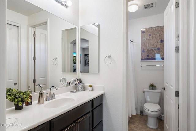 bathroom featuring vanity, toilet, and tile patterned flooring