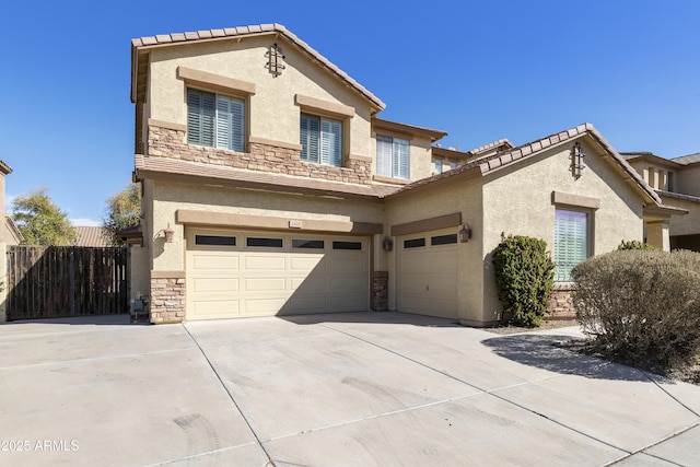 view of front of property featuring a garage, concrete driveway, stone siding, fence, and stucco siding