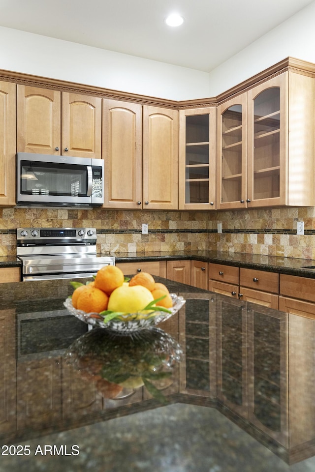 kitchen with glass insert cabinets, dark stone countertops, stainless steel appliances, backsplash, and recessed lighting