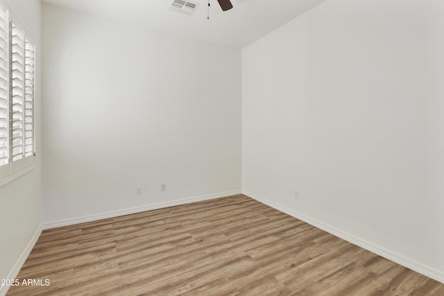 unfurnished room with a ceiling fan, light wood-type flooring, visible vents, and baseboards