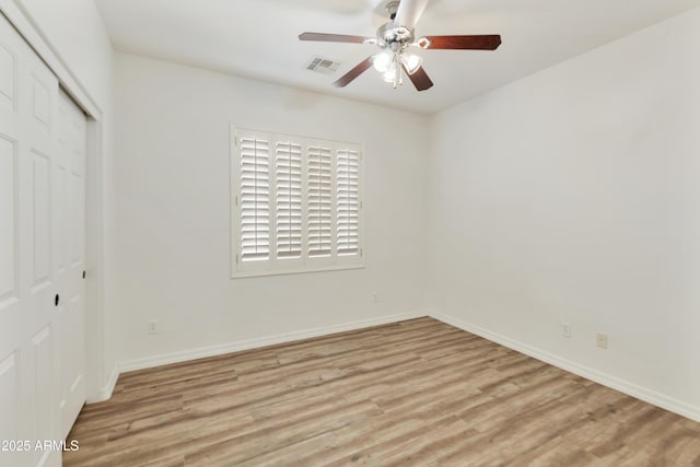 unfurnished bedroom with light wood-type flooring, baseboards, visible vents, and a closet