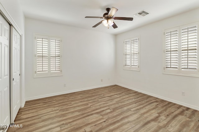 unfurnished bedroom with light wood-style flooring, visible vents, baseboards, and a closet