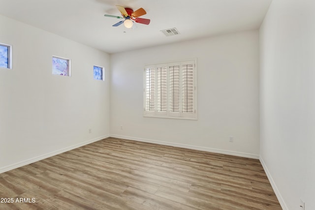 unfurnished room featuring light wood-style floors, visible vents, ceiling fan, and baseboards