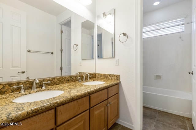 bathroom with double vanity, baseboards, a sink, and tile patterned floors