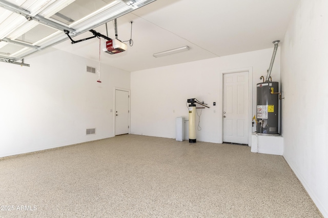 garage with water heater, visible vents, and a garage door opener