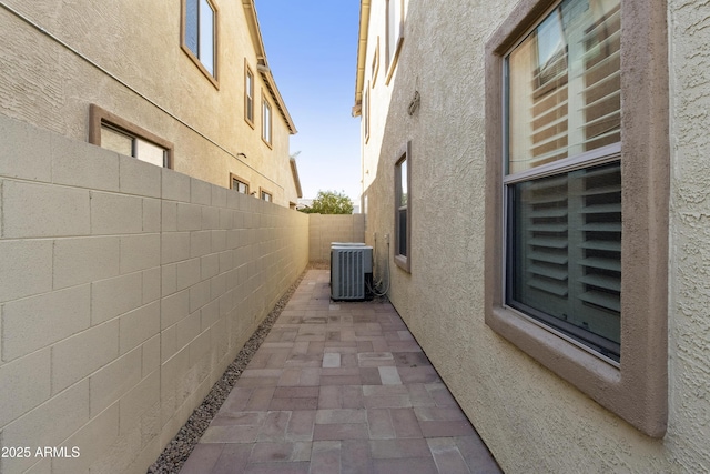 view of home's exterior with a fenced backyard, central AC unit, a patio, and stucco siding