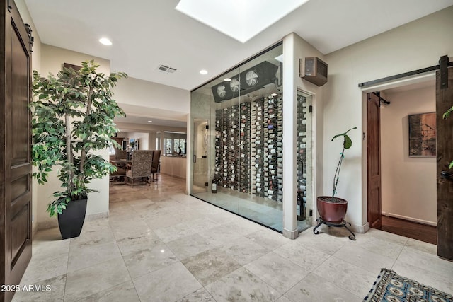 wine area featuring a barn door, recessed lighting, and visible vents