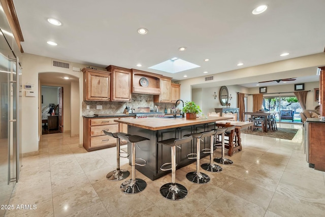 kitchen with visible vents, a kitchen breakfast bar, and a sink