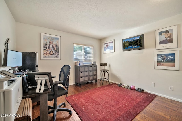 office space featuring baseboards, a textured ceiling, and hardwood / wood-style floors