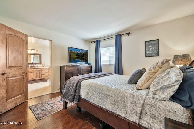 bedroom with connected bathroom and dark wood-style flooring