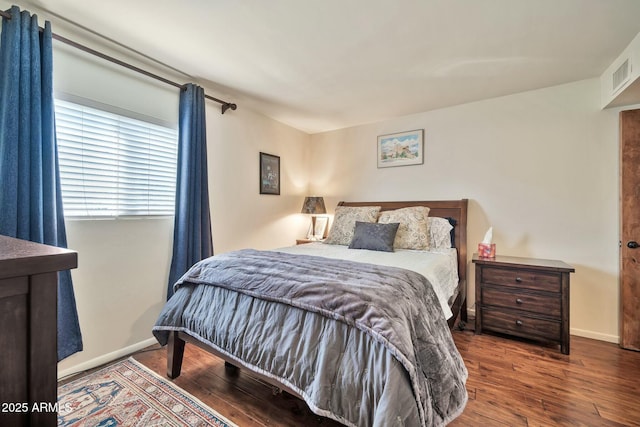 bedroom featuring wood finished floors, visible vents, and baseboards