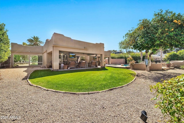 back of house with a patio, a yard, fence, and stucco siding