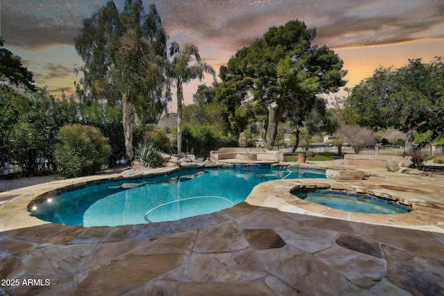 pool featuring an in ground hot tub and a patio area